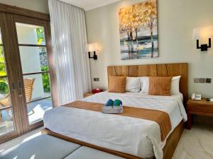 een slaapkamer met een groot bed met schoenen erop bij Peninsula Bay Resort in Nusa Dua