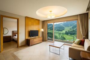 Oak Valley Resort في ونجو: غرفة معيشة بها أريكة وتلفزيون