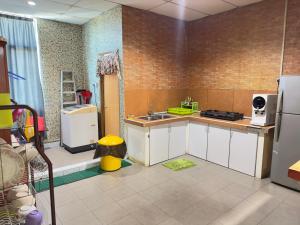 uma cozinha com um lavatório e um frigorífico num quarto em VIE HOMESTAY TAWAU em Tawau