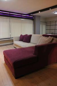 - un salon avec un canapé blanc et des oreillers violets dans l'établissement Modern Loft in the city center of Levadia, Greece, à Lébadée