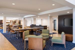 un ristorante con tavolo, sedie e TV di Courtyard Salt Lake City Airport a Salt Lake City