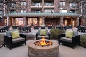 een vuurplaats met stoelen en tafels en een gebouw bij Courtyard Salt Lake City Airport in Salt Lake City