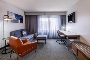 a hotel room with a couch and a desk at Courtyard Salt Lake City Airport in Salt Lake City