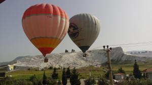 two hot air balloons flying over a mountain at Hotel Goreme Sakura in Pamukkale