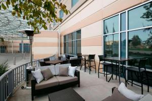 a balcony with a couch and tables and windows at Courtyard Indianapolis Downtown in Indianapolis