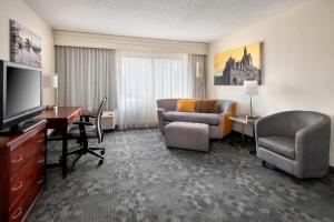 a hotel room with a desk and a living room at Courtyard by Marriott Princeton in Princeton