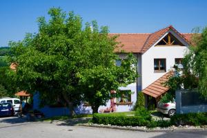 Una casa blanca con un árbol delante. en Pension Ferda, en Český Krumlov