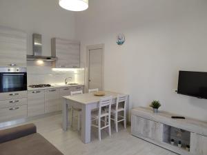 a kitchen with a table and a tv in it at GHETTO DELLE STELLE in Lampedusa