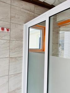 a sliding glass door in a bathroom with a stone wall at Casa BB&Djassi in Ponta do Sol