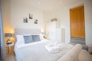 - une chambre avec un lit blanc et des serviettes dans l'établissement Hammersmith Apollo 1 Bedroom Apartment, à Londres