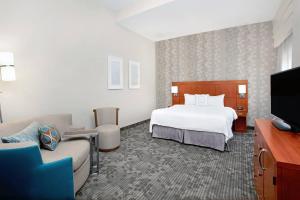 a hotel room with a bed and a flat screen tv at Courtyard by Marriott St. Augustine I-95 in Saint Augustine