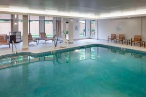 a pool in a hotel with chairs and tables at Courtyard Tuscaloosa in Tuscaloosa