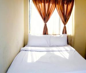 a bed in a room with a window at Asmara Hotel in Johannesburg