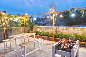 a patio with two tables and a grill with lights at Cloud River Homestay in Da Lat