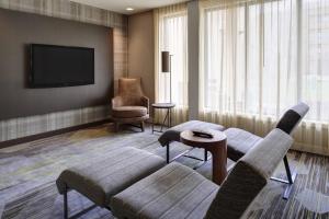 a living room with a couch and a tv at Courtyard by Marriott Indianapolis Airport in Indianapolis