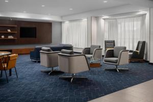 a waiting room with chairs and a flat screen tv at Courtyard Jacksonville Butler Boulevard in Jacksonville