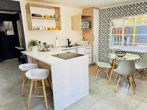 a kitchen with a counter and a table and chairs at Lemon Ivy Guesthouse in Polokwane