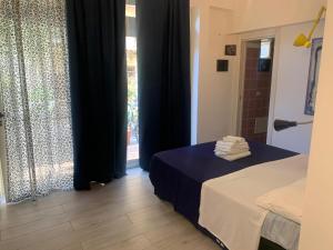 a room with a bed and a window with black curtains at Accomodation Libertino in Tropea