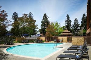 a swimming pool with lounge chairs next to a building at Courtyard by Marriott Santa Rosa in Santa Rosa