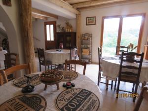 een eetkamer met tafels en stoelen en een kamer met ramen bij l'altore di savaghju in Vivario