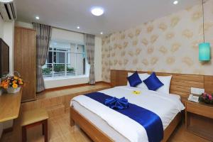 um quarto com uma cama com um arco azul em Ailen Hotel em Ho Chi Minh