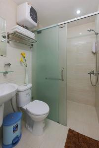 a bathroom with a toilet and a glass shower stall at Ailen Hotel in Ho Chi Minh City