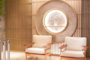 two chairs in a room with a round mirror at Travelodge Kyoto Shijo Kawaramachi in Kyoto