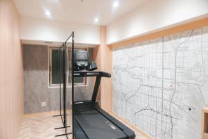 a room with a treadmill next to a wall with a map at Travelodge Kyoto Shijo Kawaramachi in Kyoto