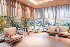 a lobby with two chairs and a table and windows at Travelodge Kyoto Shijo Kawaramachi in Kyoto
