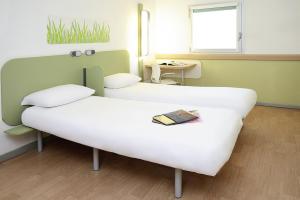 um quarto de hospital com duas camas e uma mesa em ibis Budget Courbevoie Paris La Défense em Courbevoie