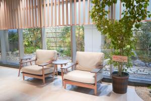two chairs and a table in a room with windows at Travelodge Kyoto Shijo Kawaramachi in Kyoto