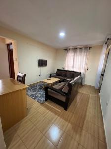 a living room with a couch and a table at Citypal Apartments in Meru