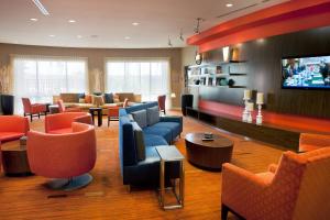 a lobby with couches and chairs and a flat screen tv at Courtyard Foothill Ranch Irvine East/Lake Forest in Foothill Ranch