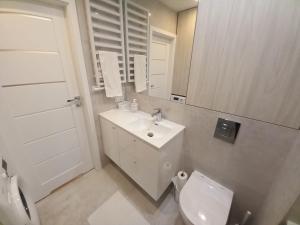 W łazience znajduje się umywalka, toaleta i lustro. w obiekcie LoveKrakow w Krakowie