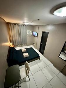Cette chambre comprend un lit et une chaise. dans l'établissement Inn De Avenida, Makati, à Manille