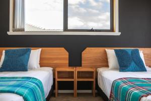 een hotelkamer met 2 bedden en een raam bij Mountain Explorer - perfect base for exploring in Deloraine