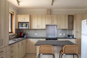 a kitchen with wooden cabinets and a counter top at Mountain Explorer - perfect base for exploring in Deloraine