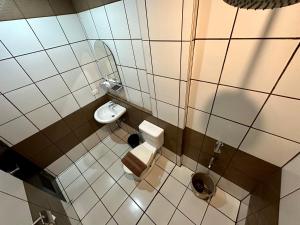 La petite salle de bains est pourvue de toilettes et d'un lavabo. dans l'établissement Inn De Avenida, Makati, à Manille