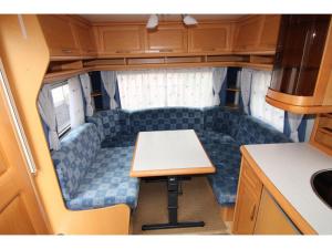 um pequeno quarto com uma mesa na parte de trás de um rv em Nowoczesne przyczepy kempingowe Chałupy Royal-Camp em Chałupy