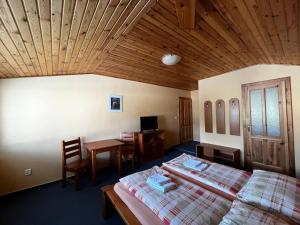 a bedroom with two beds and a wooden ceiling at Penzión Mizuna in Hrabušice