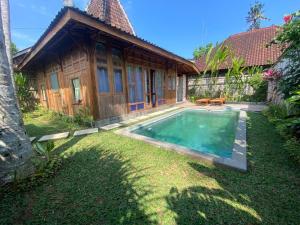 a house with a swimming pool in front of it at Sarini Villas in Blahbatu