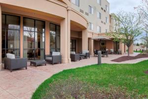 eine Terrasse mit Stühlen und Tischen außerhalb eines Gebäudes in der Unterkunft Courtyard by Marriott Potomac Mills Woodbridge in Woodbridge