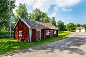 czerwona stodoła przy drodze w obiekcie Långvinds Bruk - Vandrarhem w mieście Enånger