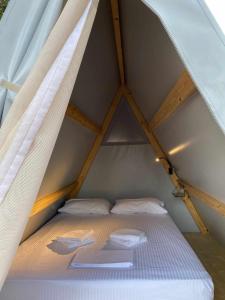 1 cama en el medio de una habitación pequeña en Nirikos Camping, en Spasméni Vrísi