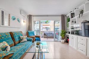 a living room with a blue couch and a glass table at Selene in Calpe