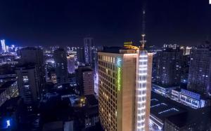 um edifício iluminado numa cidade à noite em Holiday Inn Taiyuan City Center em Taiyuan