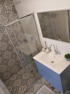 a bathroom with a sink and a mirror at הבית ליד הבוסתן דירה לזוג in Mikhmannim
