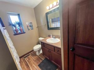 a bathroom with a sink and a toilet and a mirror at Bridges Bay Vacation Cabin 33 in Arnolds Park