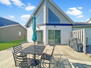 a table with chairs and an umbrella in front of a house at Bridges Bay Vacation Cabin 33 in Arnolds Park