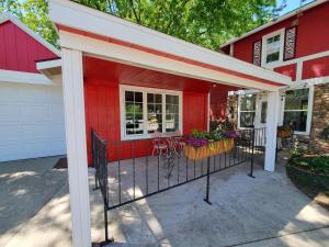 a red house with a porch with flowers on it at 127 Hwy 71 AT Bunk House in Arnolds Park +6 photos